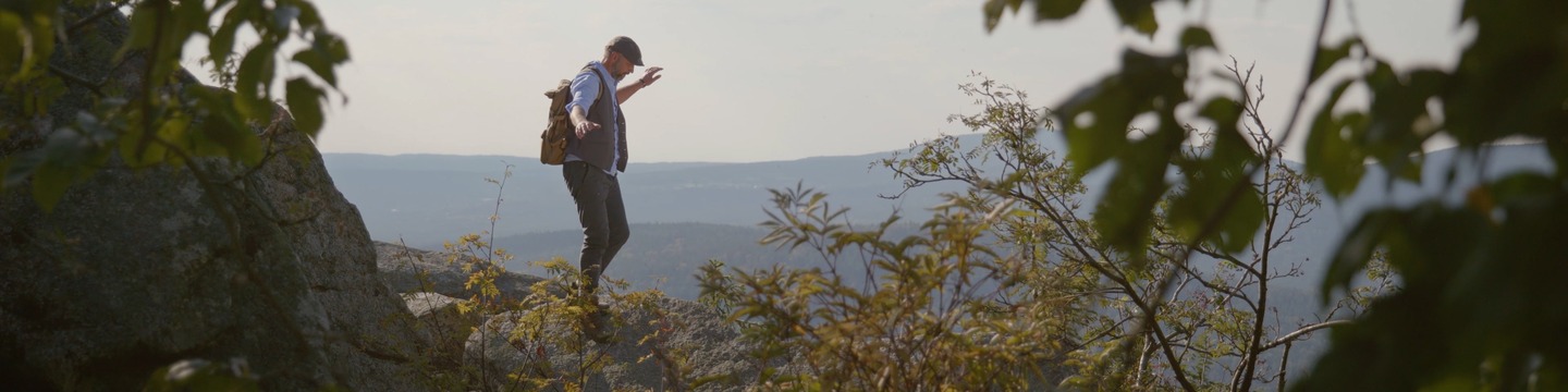Werner balanciert auf Stein, im Hintergrund sieht man die Fichtelgebirgslandschaft