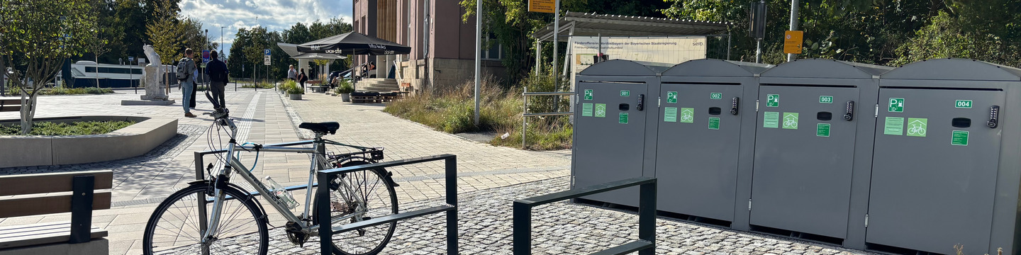 Fahrradabstellanlagen mit Bahnhofsvorplatz im Hintergrund