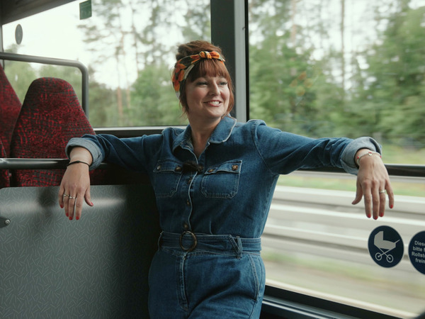 Wernerette steht lächelnd im Bus